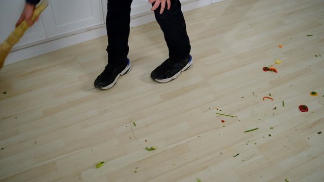 someone sweeping the floor in the kitchen