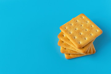 Crispy cracker on a blue background. Salty tea biscuits. Healthy Diet Snack..