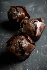 Homemade chocolate muffin on the rustic background. Selective focus.