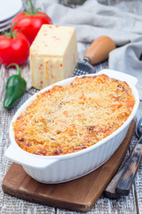 Spicy tomato jalapeno mac and cheese with mini penne pasta, in a baking dish, vertical