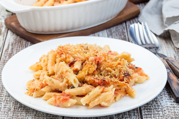 Spicy tomato jalapeno mac and cheese with mini penne pasta, on a plate, closeup, horizontal