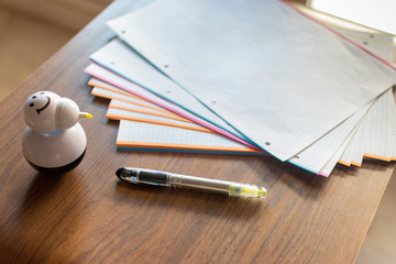 wooden table with folios, a pen and an highlighter