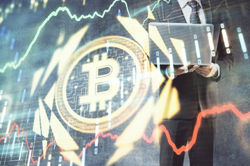 Crypto currency theme hologram with businessman working on computer on background. Concept of blockchain. Double exposure.