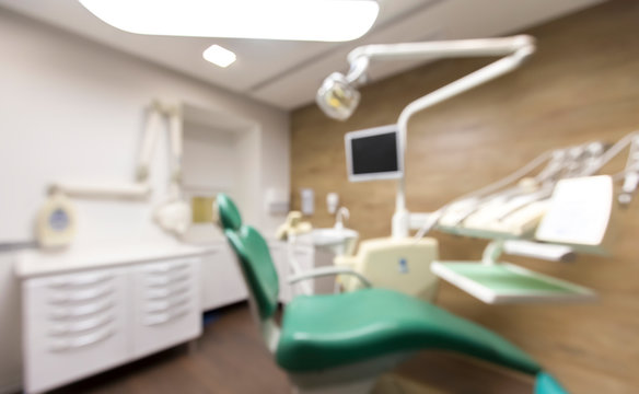 Blurred photo of modern dental office with chair and monitor