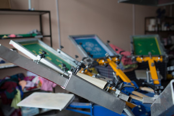 Silk screen printing. Serigraphy. Color paints and fabric. Carousel machine.