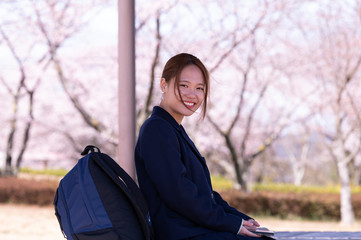 春の公園で微笑む女子高生