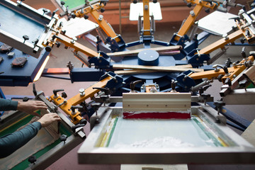 Silk screen printing. Serigraphy. Color paints and fabric. Carousel machine.