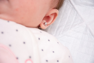 Earring in the ear of a newborn baby girl