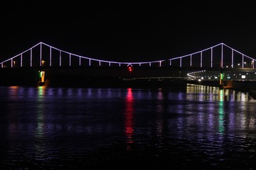 Night bridge. Reflection of lanterns in the river