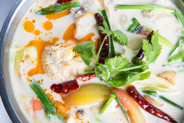 coconut chicken soup with ginger galangal tomato and lemon grass top with dry chili and coriander closeup shot