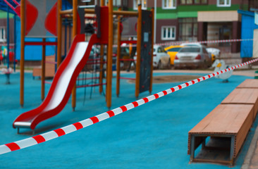 Fototapeta na wymiar Children's playground fenced with tape. Restricted area during coronavirus or covid 19 virus.