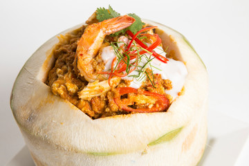 thai steamed red curry with shrimp top with coconut sause and coriander and paprika chili serve in coconut fruit