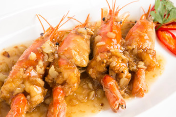 fired giant freshwater prawn with garlic sauce serve in white plate closeup shot