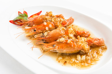 fired giant freshwater prawn with garlic sauce serve in white plate closeup shot
