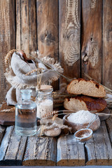 A delicious Danish or Latvian
homemade wholemeal sweet and sour rye bread from sourdough on wooden table in village. Sourdough for rye bread. Ingredients for rye Bread Made Of Sourdough