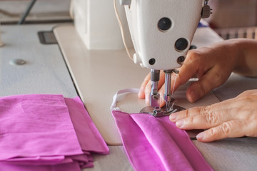 Handmade mask sewing from the fabric is used to prevent spread disease outbreaks from coughing or sneezing with dust in the air and germs close-up.