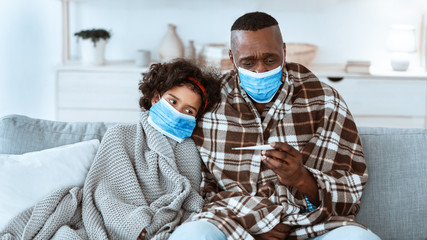 World epidemic. Mature African American man and his grandchild wearing masks and suffering from virus at home