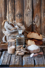 A delicious Danish or Latvian
homemade wholemeal sweet and sour rye bread from sourdough on wooden table in village. Sourdough for rye bread. Ingredients for rye Bread Made Of Sourdough