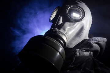 Gas mask with clouds of smoke on a dark background. Sign of radioactive contamination. Means for...