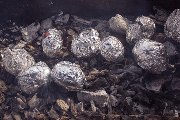 baked potatoes on the coals. wrapped in foil and baked on the grill