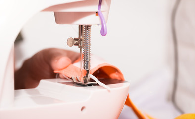 Woman hand using a sewing machine to make mask face fabric, Health care, and coronavirus protect with sew mask homemade.