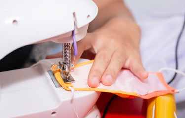 Woman hand using a sewing machine to make mask face fabric, Health care, and coronavirus protect with sew mask homemade.