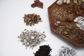 Chinese medicine and herbs are in wooden trays, they are in a white background. Chinese prescription close-up Top view