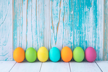 Colorful Easter eggs on blue wooden background. Easter card, background, paschal mock-up, frame with empty space.