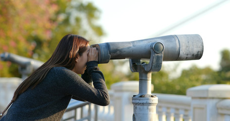 Fototapeta na wymiar Woman tourist looking though the binocular at outdoor