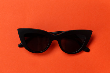 Fashionable sunglasses on an orange background.