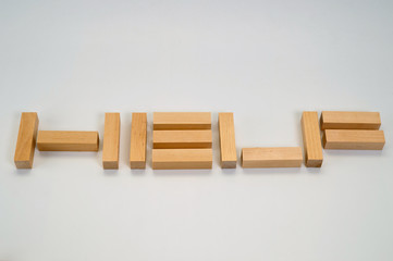 The word Help laid out by wooden blocks on a white background. Background to help those in need.