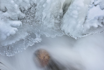 Winter landscape of the Orangeville Creek cascade framed with icicles and captured with motion blur, Michigan, USA