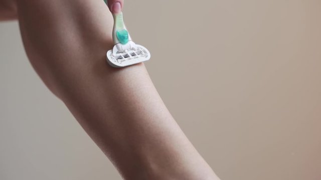 Ternopil/Ukraine - March 25, 2020: young woman shaving legs with razor Gilette in bathroom