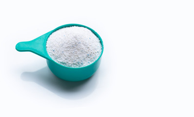 Measuring scoop with laundry powder on white background.