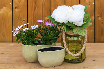 Glass, porcelain and ceramic flower vases on a wooden background.