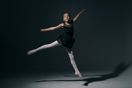 Delicate girl ballerina dancing in studio