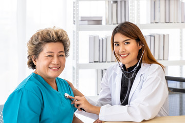 Asian female medical doctor use stethoscope to listen examine check senior elderly patient’s...
