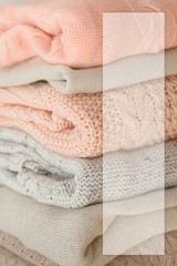 Stock Photo - Stack of cozy knitted sweaters with blank business card. For design presentations and portfolios.