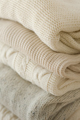 Stock Photo - Stack of cozy knitted sweaters