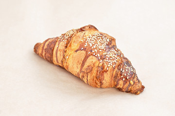 Croissant with sesame seeds Fresh baked puff pastry. Closeup on a light background
