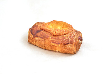 Sausage in puff pastry with baked cheese. Closeup on a light background