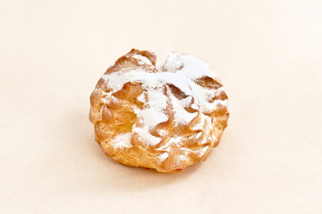 Custard tart dusted with powdered sugar. Sweet bread closeup on a light background