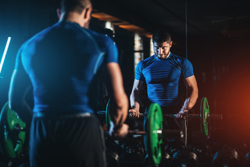 young athlete has physical workout with barbell in modern gym