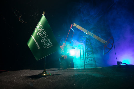 Business dialogue, oil agreement concept: National flags with Oil pump and oil refining factory at night with fog and backlight. Energy industrial concept.