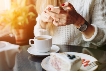 girl in a cafe in the hands of a smartphone