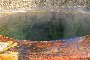 Steam from famous natural hot spring well in Raksa Warin public park, Ranong, Thailand.