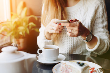 girl in a cafe in the hands of a smartphone