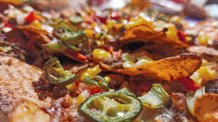 Mexican nachos tortilla chips with cheddar and jalapeno. Homemade  traditional mexican food served with cheddar cheese and jalapenos. 