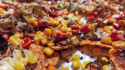 Mexican nachos tortilla chips with cheddar and jalapeno. Homemade  traditional mexican food served with cheddar cheese and jalapenos. 