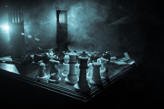 Chess figures on a dark background with smoke and fog. Selective focus